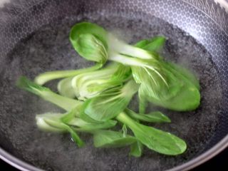 13、冬至美食~番茄青菜牛肉面,另起锅倒入适量的清水煮沸,加入少许盐和几滴花生油,放入青菜煮至变色断生的时候,捞出沥干水分。