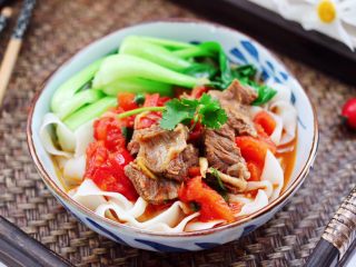 16、冬至美食~番茄青菜牛肉面,把沥干水分的面条放入碗底,上面浇上做好的番茄牛肉汤汁,边上码上青菜即可享用了。