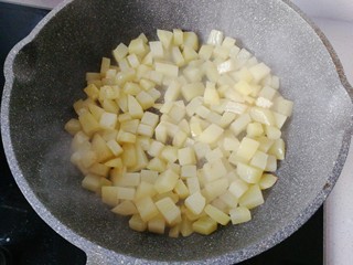 7、香煎土豆鸡胸肉丁,不沾锅先放少许油，然后倒入土豆丁小火煎制；（不要翻炒，让它煎至微黄后再翻面煎）