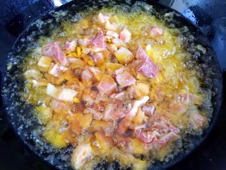 11、辣子鸡丁,锅内倒入玉米油烧至6成热，倒入腌制好的鸡丁炸一下。