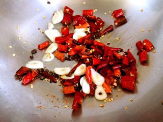 13、辣子鸡丁,锅内放少许油，放入麻椒、干红辣椒、大蒜片爆香。