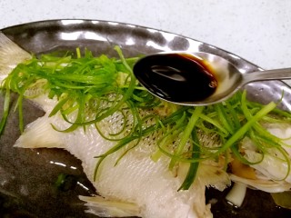 15、粤式清蒸鲈鱼,往鱼身上均匀地淋浇3勺生抽。