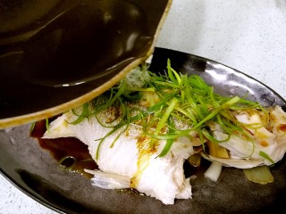 16、粤式清蒸鲈鱼,从头到尾浇上热油。