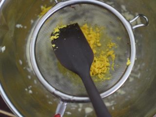 4、巧克力豆玛格丽特饼干,然后将煮熟的蛋黄过筛到黄油盆子里。用刮刀压按的方式过筛很容易过筛下去的。
