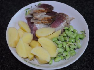 1、懒人餐，一锅出——腊肉排骨饭,所有的食材准备好，土豆分两部分，一部分切片，用来排放在上面，一部分切成滚刀块，和米饭一起煮，排骨切成小段，腊肉切薄片，青豆清洗干净备用