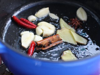 7、西红柿炖牛肉,锅中倒适量食用油烧至五成热，放入姜、蒜、八角、桂皮和红干椒小火炒香