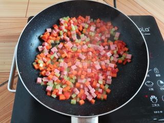 11、菠萝蛋炒饭,锅里放入少量油翻炒一下蔬菜丁和火腿肠丁