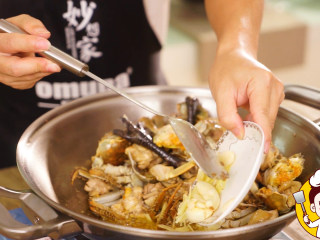 6、海鲜鸡煲蟹,再加入姜片、蒜末翻炒。