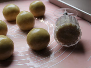 13、风炉广式豆沙月饼,将裹了玉米淀粉的面团装入模具。