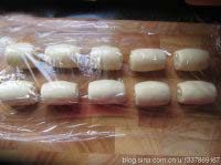 8、苏式松仁枣泥&椒盐麻仁月饼,再一次收口朝上，擀成长形，自上而下卷起来，盖上保鲜膜松弛15分钟