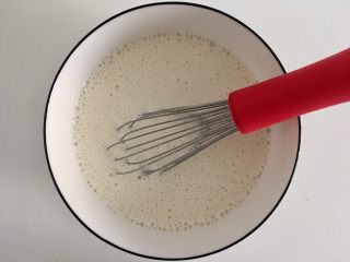 3、减肥版香蕉可丽饼,加入240ml牛奶,用手动打蛋器搅打到无颗粒