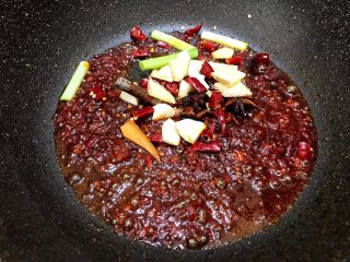 7、川香红烧牛筋牛肠,加入干辣椒，干花椒，八角，桂皮，姜蒜，青蒜白段翻炒一分钟