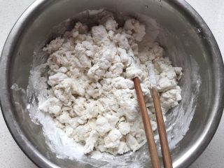 6、花生汤圆,用开水烫糯米面,一边烫一边搅拌,搅拌成絮状,再加入一些凉水,感觉面团柔软不硬就可以不用加凉水了,揉成一个面团。