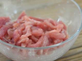 3、百吃而不腻的经典饭菜——青椒肉丝饭,倒入一勺盐、淀粉、料酒,搅拌均匀,腌制10分钟。