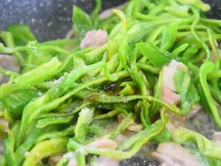 6、百吃而不腻的经典饭菜——青椒肉丝饭,待肉丝炒至变色倒入青椒丝、耗油、一勺糖、一勺盐翻炒均匀。