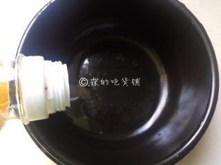 3、腊肠煲仔饭,锅里倒入少许食用油，把锅底和锅壁全部抹上一遍。