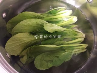 6、腊肠煲仔饭,把洗净后的小青菜放入汆烫一下（随便你是什么绿叶蔬菜，都需要汆烫一下，否则后面焖不熟的哦。）