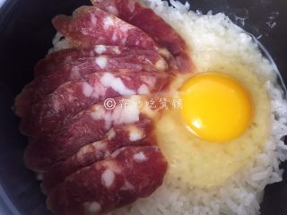 13、腊肠煲仔饭,那边米饭煮至六七分熟时，把腊肠放入，再磕入一个鸡蛋。