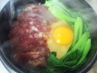 14、腊肠煲仔饭,然后再放上绿叶菜，盖上锅盖再焖个3、5分钟就可以了。