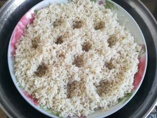 6、广式糯米鸡,平铺好糯米后用手指插几个洞，避免中间的糯米没蒸熟