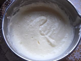 6、香草魔法蛋糕,将蛋白倒入蛋黄糊中，用手抽翻拌，但不要翻拌均匀，表面的蛋白用划圈的方式让它表面被蛋黄糊包裹，却不会沉底