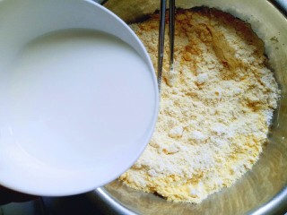 5、玉米花朵馒头,分次加入牛奶，用筷子挑成絮状，再揉成面团。(面粉吸水性不同，所以需要分次加入牛奶)