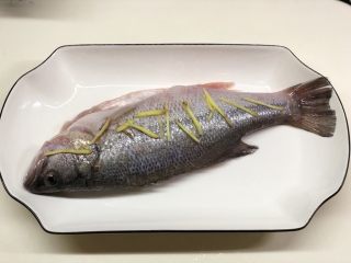 11、椒香葱油鲈鱼,取几根姜丝放置于鱼身上