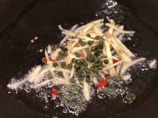 16、椒香葱油鲈鱼,热锅冷油，放入姜丝、藤椒、小米椒，煸一会