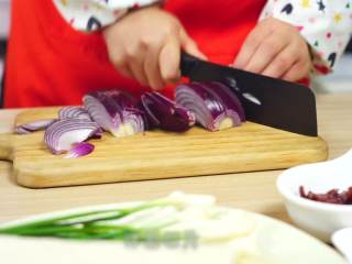 2、干锅千页豆腐,准备好食材之后,我们先把带脂猪肉切片,洋葱切丝