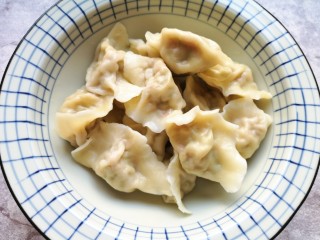 16、冬至美食  红油干拌饺子,煮好的饺子捞出，盛在一个大碗里面散一下热气。