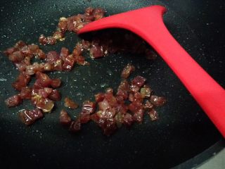 5、电饭锅土豆腊肠饭,当腊肠开始出油时转小火,继续煎致腊肠有点变色时,控油捞起腊肠