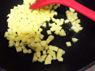 6、电饭锅土豆腊肠饭,锅里的腊肠油不倒掉,留着,开火,中火,放入土豆丁翻炒10秒