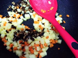 7、电饭锅土豆腊肠饭,放入红萝卜丁,继续翻炒10秒