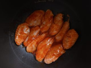 5、电饭煲食谱合集,将腌制好的鸡翅 排入锅中,摆好鸡翅后 将盆子里腌制鸡翅的汁液也一起倒入锅中