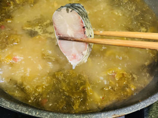 17、炖草鱼,用筷子夹起鱼块，一块块放入，刚才腌鱼汁就不要了；