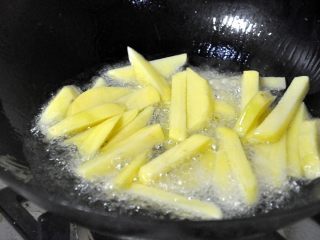 2、孜然土豆条,锅中热油，倒入控干水份的土豆条，炸至金黄色。