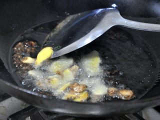 5、孜然土豆条,倒入姜、蒜，继续炒香。