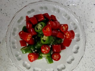 5、酸汤牛蛙,青红尖椒切圈装盘备用。