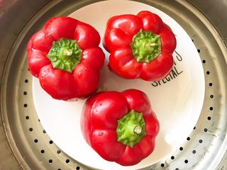 12、灯笼椒米片盅,装好用椒盖盖好,上预热好的蒸笼蒸3-4分钟。如果冷水蒸,就蒸7-8 分钟。目的在于外层的辣椒蒸后柔软一些