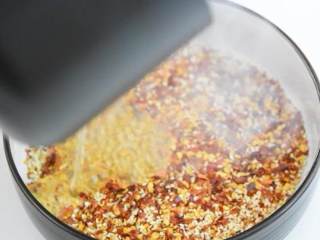 3、自己动手做辣椒油，好吃又卫生,往辣椒芝麻里倒入热油。