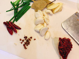 3、芋头烧鸡,葱切段，干辣椒，小米椒，花椒备好，掰好4块蒜，准备好1勺豆瓣酱，3片香叶，3片姜片切好