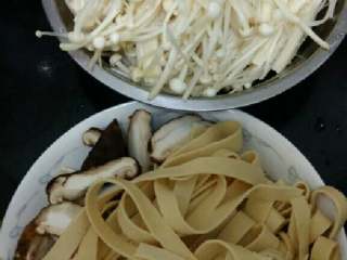 1、老干妈火锅,金针菇切根部，洗净，撕开，豆皮切条。香菇洗净切片