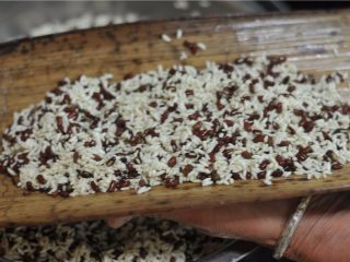 5、鲜掉眉毛的湘西特色美食——笋壳腊肉棕,舀一勺糯米红豆放在笋壳叶子中间，用手将米粒稍微弄平整