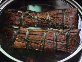 11、鲜掉眉毛的湘西特色美食——笋壳腊肉棕,将做好的粽子放在锅里，加入没过的水，我的容器小了点，水没有没过粽子，所以在煮的时候要将它们翻个面，以防有些熟了有些没熟
