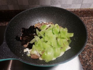 12、莴笋炒牛肉,放入木耳和莴笋翻炒片刻。