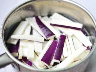 2、辣酱烧茄子,茄子切成长条，在清水中浸泡一会，（炒制的时候就不会吸入过多的油份）随后捞出，控干水分