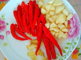 2、自制剁椒,所需材料洗净晾干水，辣椒去柄，用刀把每一个都划上几刀，大蒜去皮也用刀切成2半，姜切成片