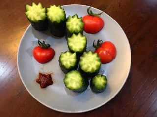 4、鸳鸯锅重庆火锅配老北京清汤锅,将黄瓜洗净后,去头去尾,均匀切几段,用磨具压花型摆盘,将圣女果洗净斜切一刀,在对半切开,在造型摆盘,旁边放少许甜辣酱