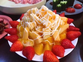 8、鸳鸯锅重庆火锅配老北京清汤锅,将橙子去皮切小块摆盘底,将哈密瓜去皮切成小块摆上,苹果去皮切成小块摆上,草莓洗净去蒂切开摆周围淋上沙拉酱