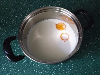 2、蓝莓果酱冰淇淋,蛋黄、白糖和牛奶倒入奶锅中